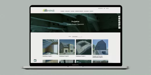 Mockup der Webseite der HINS Zimmerei auf einem Macbook-Display