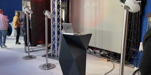 Bühne mit Podium, VR-Stelen und Hintergrund mit weißem Vorhang.