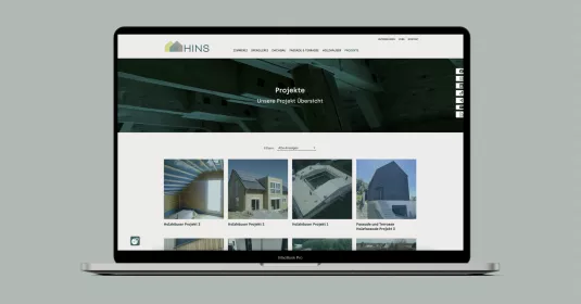 Mockup der Webseite der HINS Zimmerei auf einem Macbook-Display