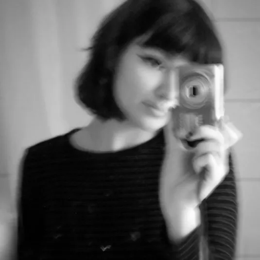 Gloria mit ihrer kleiner Digicam vor einem Spiegel.