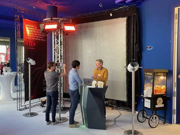 Menschen bedienen VR Stelen in einer blau beleuchteten Halle.